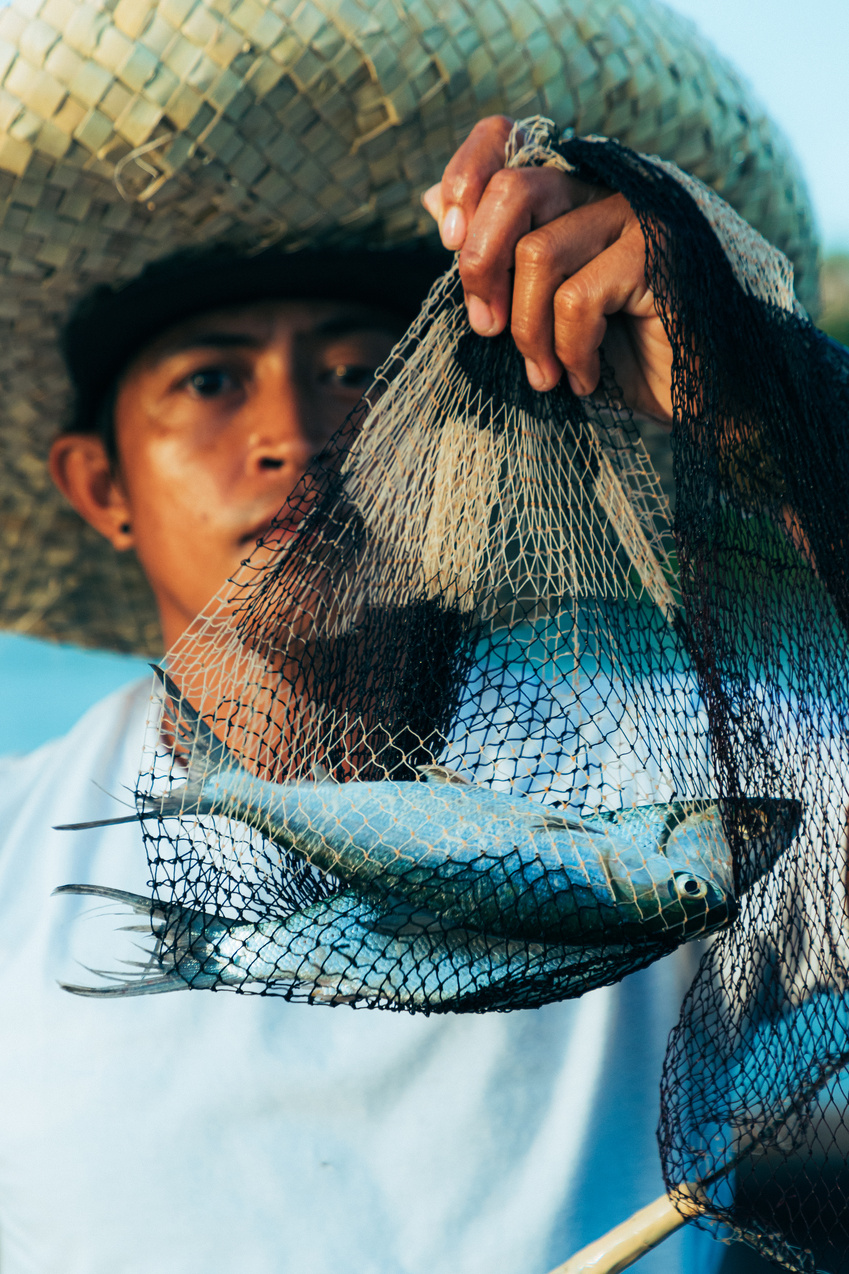 Fisherman Holding Net with Caught Fish